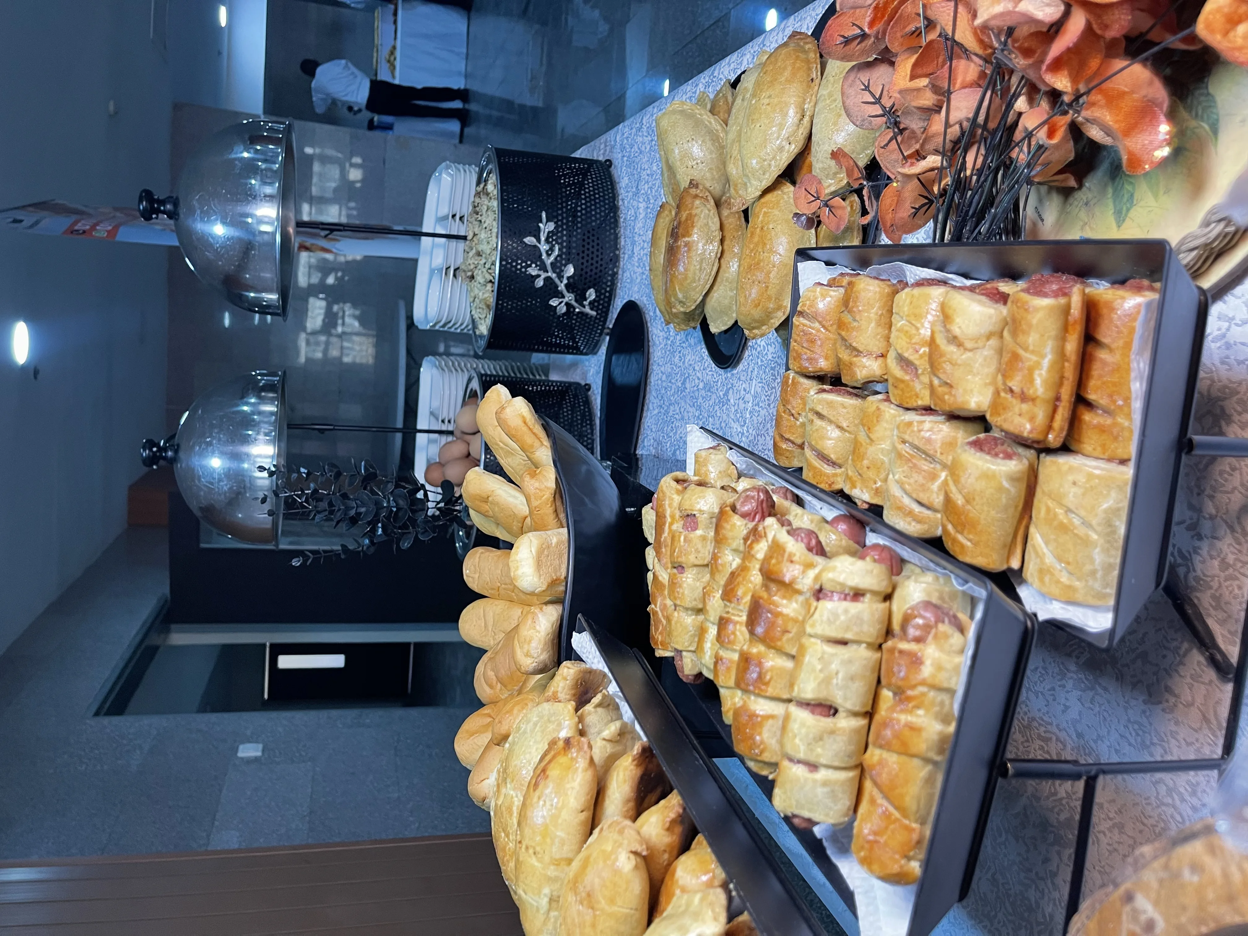 Bread and pastry spread at a breakfast buffet station