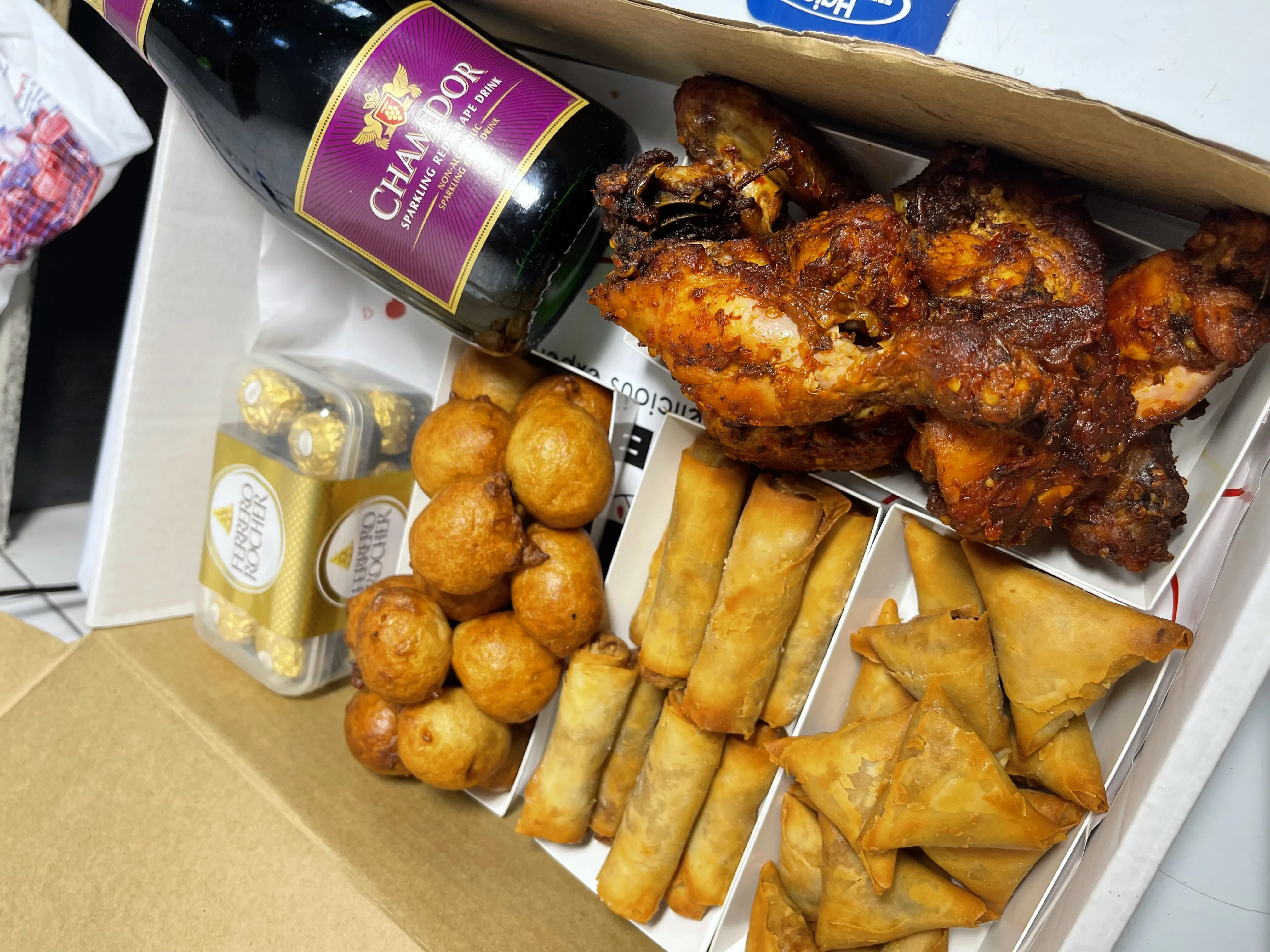 Party box with small chops, fried chicken, and champagne