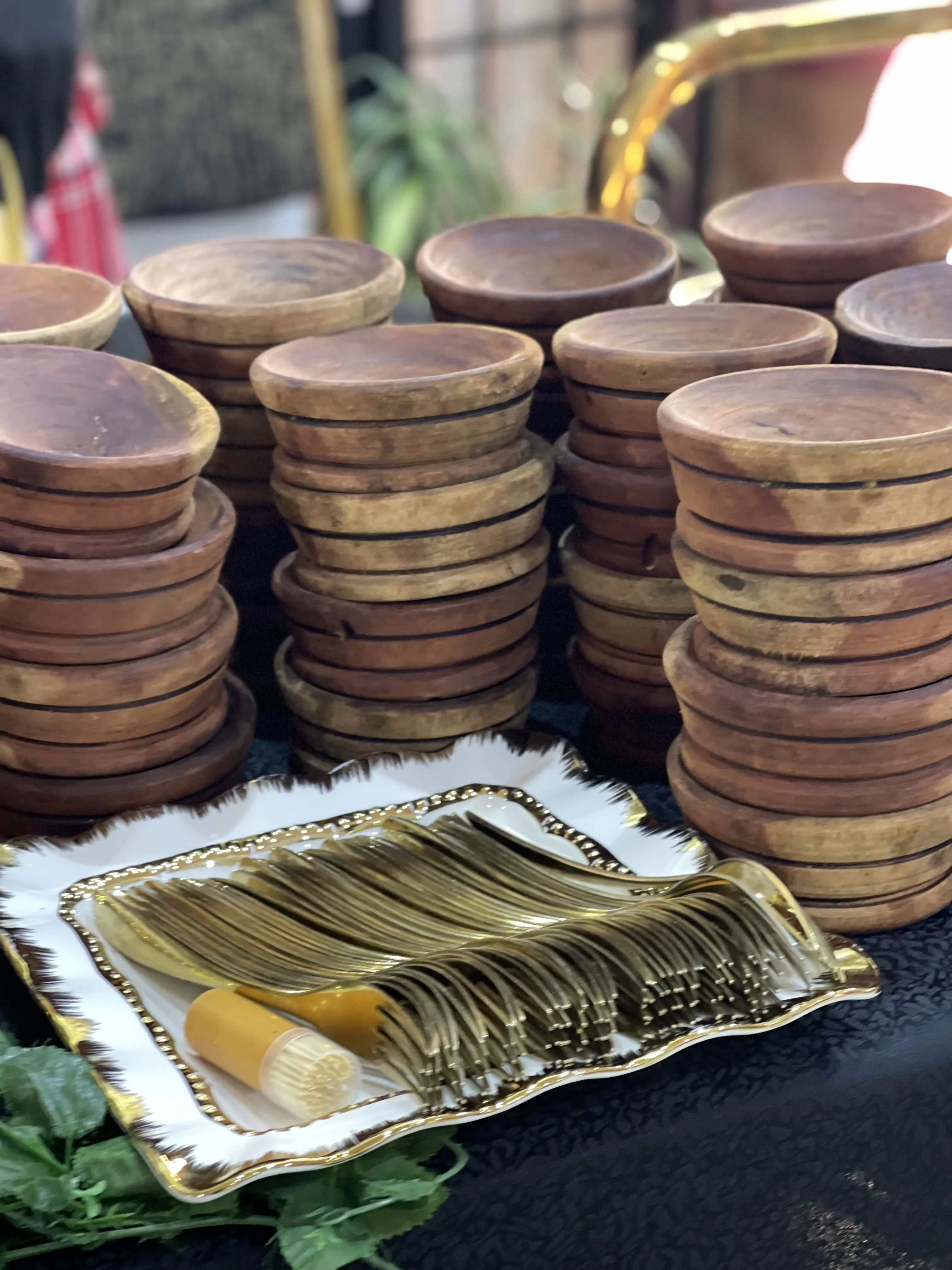 Stacked wooden serving bowls with golden cutlery set